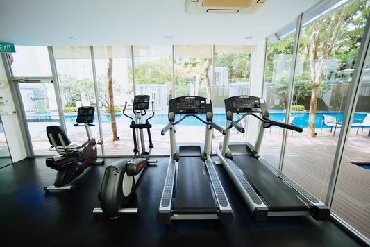 black treadmills and elliptical trainers in glass room