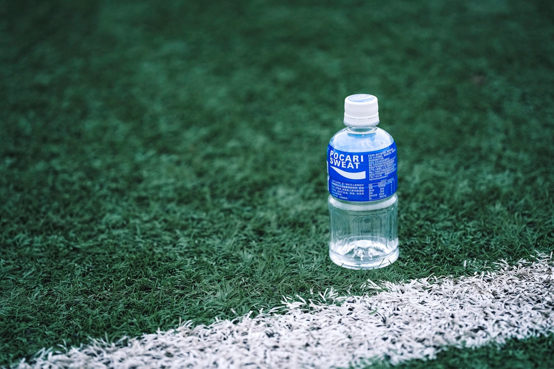 a bottle of water on a gravel surface