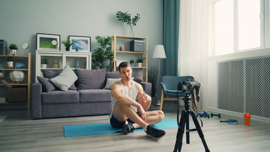 a man sitting on a yoga mat in front of a camera