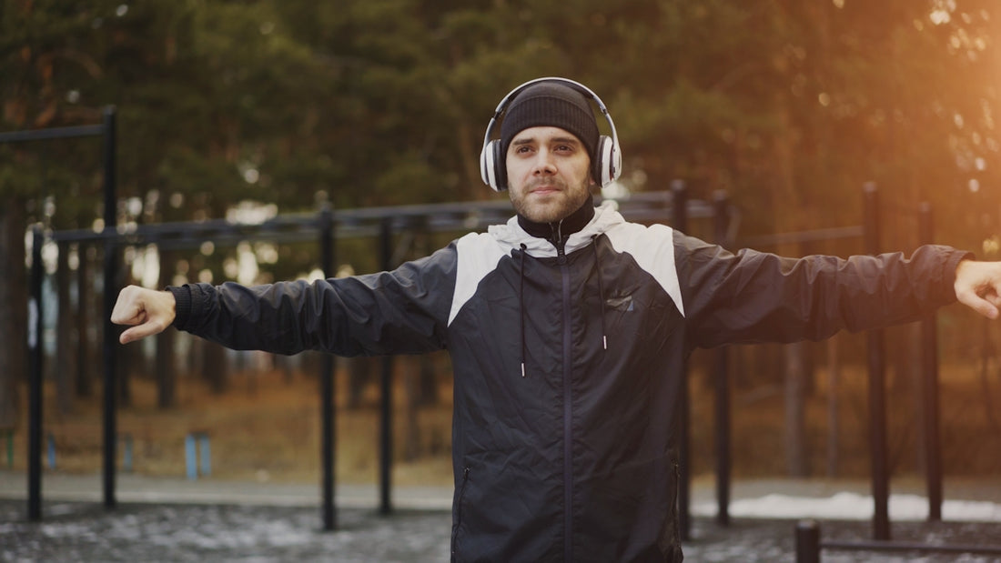 Man with headphones stretching outdoors