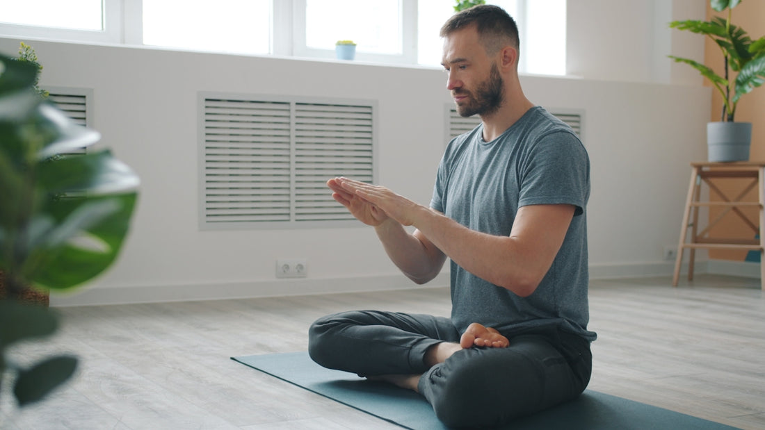 Man meditating in a bright, minimalist room.