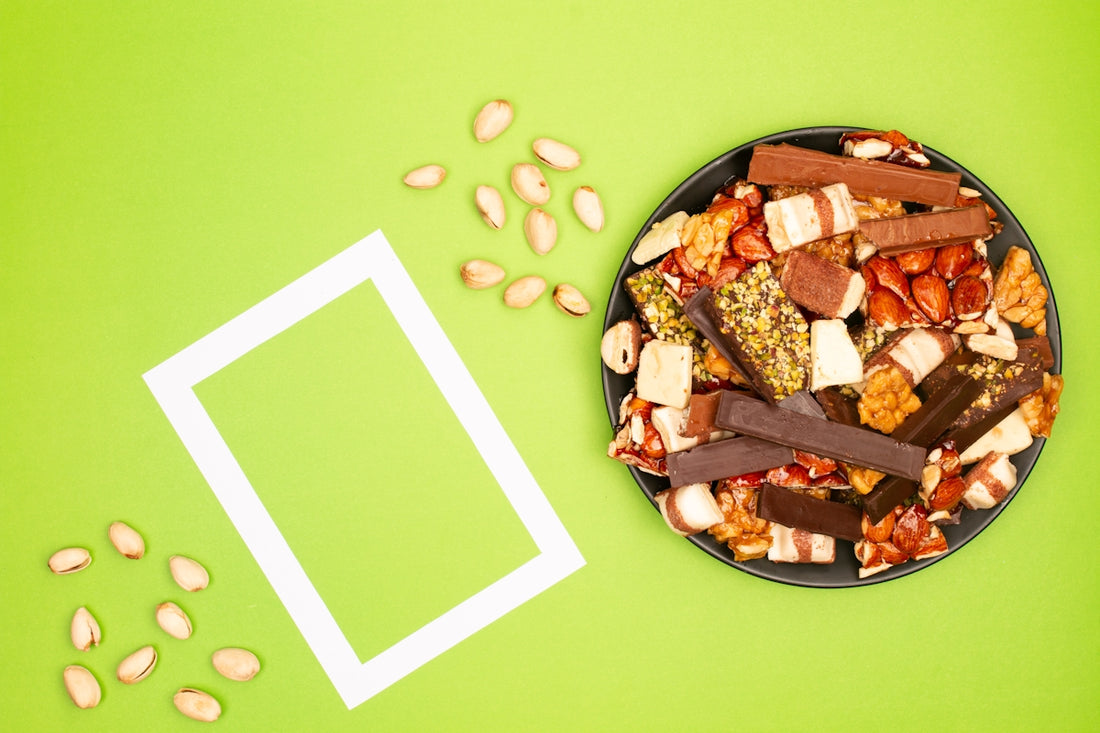 A dark plate filled with various energy bars and nuts.